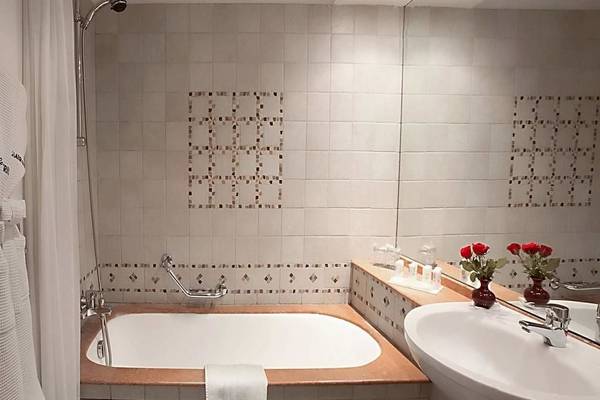 Badezimmer im Le Meridien N'Fis Hotel mit Badewanne, Waschbecken und Toilettenartikeln.