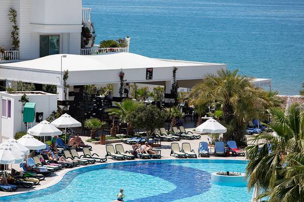 Außenbereich des Alba Queen Hotels mit Pool und Sonnenliegen am Meer