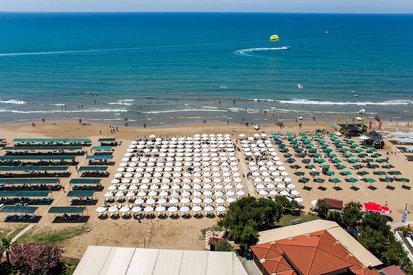 Luftaufnahme des Alba Queen Hotels, zeigt eine große Anzahl von Sonnenschirmen und Liegestühlen am Strand.