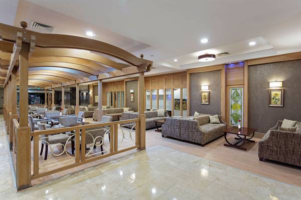 Lobby des Alba Queen Hotels mit Sofas, Tischen und Holzbalken.