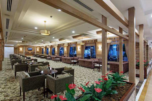 Lobby des Alba Queen Hotels mit Sofas, Tischen und Pflanzen.