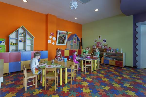 Kinderzimmer im Alba Queen Hotel mit bunten Wänden und Puzzleboden.