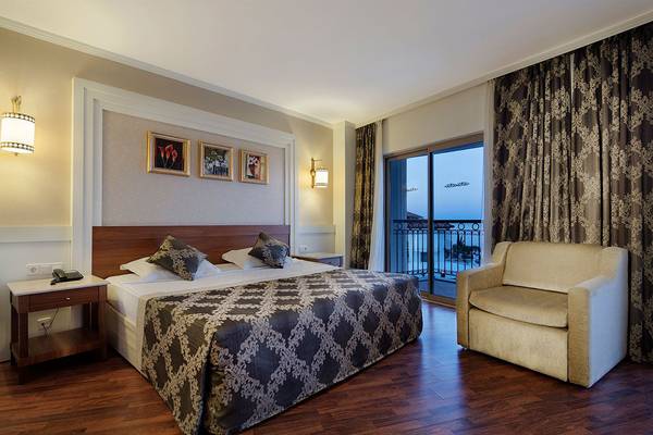 Alba Queen Hotelzimmer mit Bett, Sofa, Nachttisch und Balkonzugang.