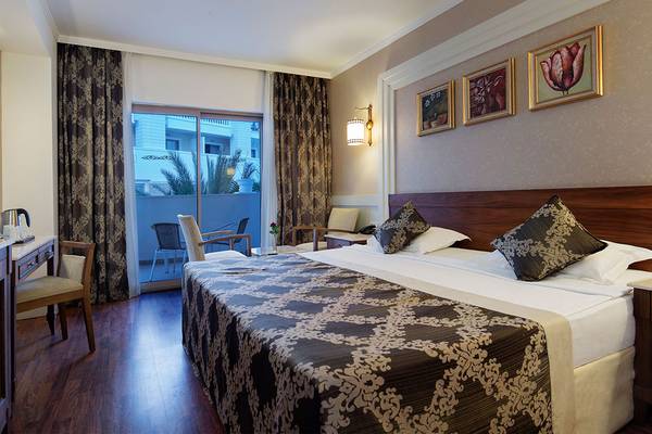 Hotelzimmer im Alba Queen Hotel mit einem Doppelbett, einem Schreibtisch, einem Sessel und einem Balkon
