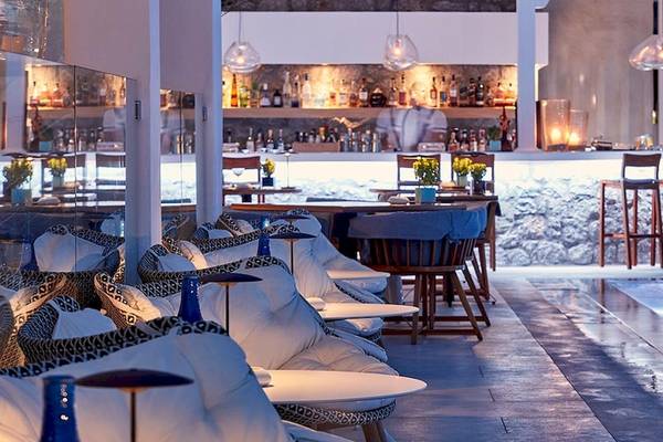 Poolbar im Myconian Kyma Hotel mit Sitzgelegenheiten und Bar im Hintergrund.