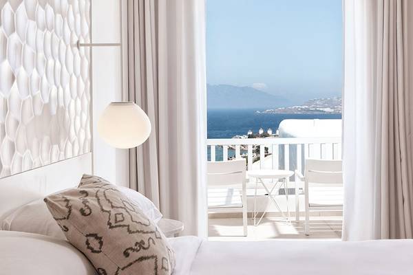 Myconian Kyma Hotel Zimmer mit Balkon und Meerblick, inklusive Tisch und Stühle auf dem Balkon.