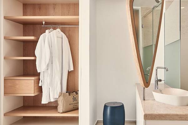 Badezimmer mit offenem Kleiderschrank, Robe, und Waschbecken im Hotel Myconian Kyma.