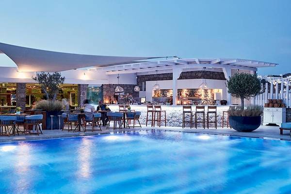 Außenbereich des Myconian Kyma Hotels mit Pool, Bar und Tischen