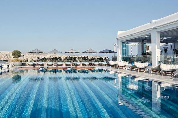 Poolbereich des Myconian Kyma Hotels mit Sonnenliegen und Sonnenschirmen