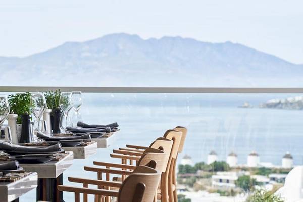 Myconian Kyma Hotel Innenbereich mit Tisch und Meerblick.
