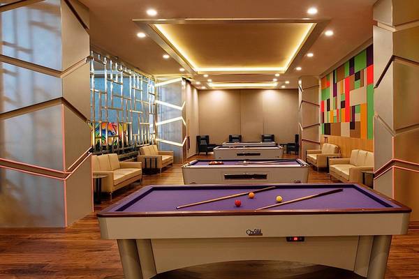 Poolraum im Regnum Carya Golf & Spa Resort mit bunten Wänden und mehreren Billardtischen.