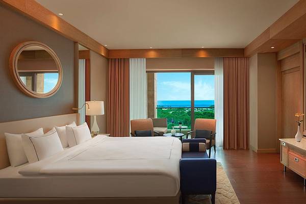 Suite-Zimmer im Regnum Carya Golf & Spa Resort mit Meerblick, großem Bett, Fernseher und Balkon.