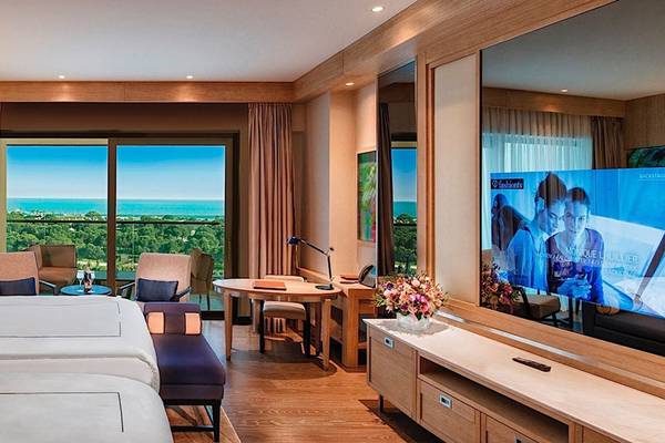 Hotelzimmer des Regnum Carya Golf & Spa Resorts mit Blick auf das Meer.