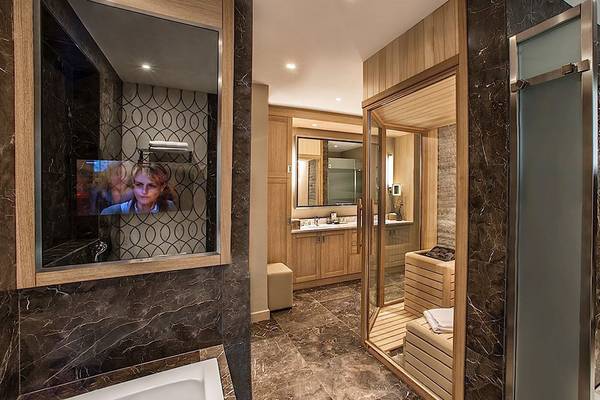 Ein Badezimmer im Regnum Carya Golf & Spa Resort mit Marmorfliesen, einer großen Badewanne und einer Dusche.