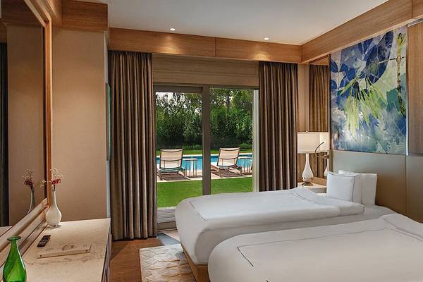 Doppelzimmer im Regnum Carya Golf & Spa Resort mit Terrasse und Swimmingpoolblick.