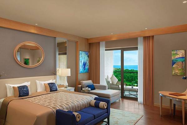 Regnum Carya Golf & Spa Resort Suite Zimmer mit Bett, Sofa, Schreibtisch und Meerblick.