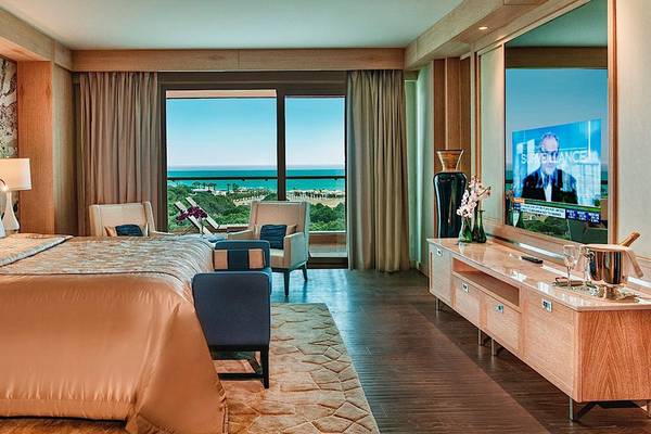 Regnum Carya Golf & Spa Resort Suite mit Meerblick, großen Bett, Fernseher und Sitzbereich.