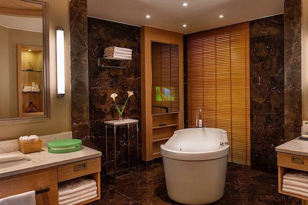 Badezimmer im Regnum Carya Golf & Spa Resort mit Badewanne, Waschbecken und Spiegel.