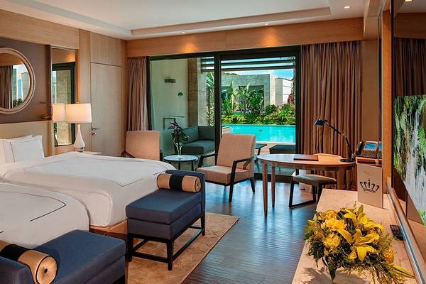 Regnum Carya Golf & Spa Resort Hotelzimmer mit zwei Betten, Swimmingpool im Hintergrund.