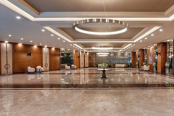Luxuriöse Lobby des Regnum Carya Golf & Spa Resorts mit Marmorboden und moderner Beleuchtung.