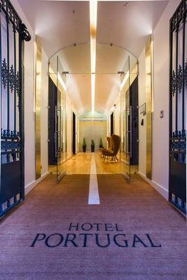 Empfangsbereich des Hotels Portugal mit gefliesten Boden, Glastüren und Möbeln.