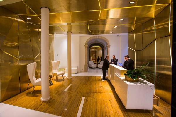 Empfangsbereich des Portugal Boutique Hotels mit goldenen Wänden und Holzboden.