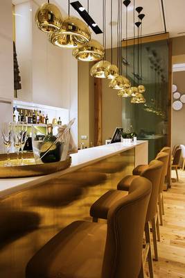 Rezeption im Hotel Portugal Boutique mit goldenen Leuchten und Barbereich.