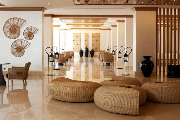 Lobby des Mitsis Blue Domes Resort & Spa mit braunen Möbeln und schwarzen Vasen.