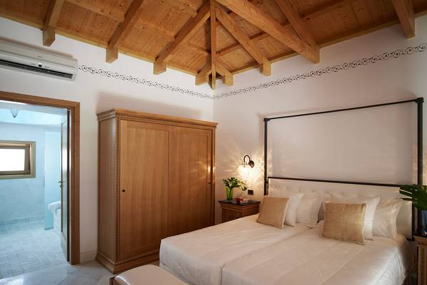 Schlafzimmer mit Doppelbett im Mitsis Blue Domes Resort & Spa
