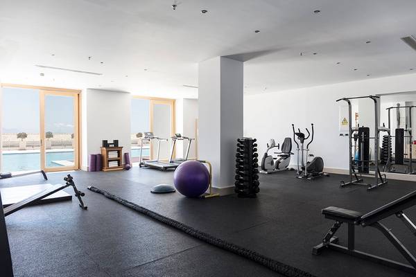 Fitnessbereich des Mitsis Blue Domes Resort & Spa mit verschiedenen Geräten und Trainingswerkzeugen.