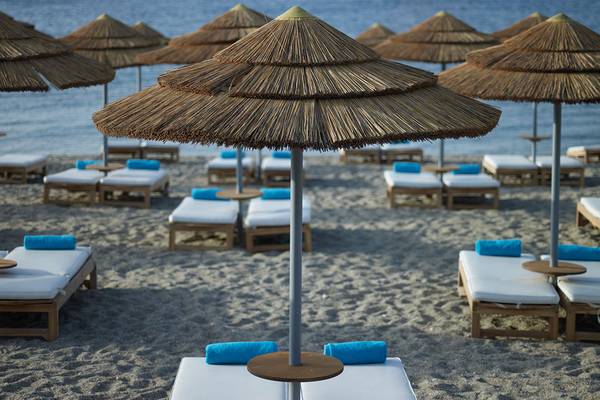 Strand mit Liegen und Sonnenschirmen im Mitsis Blue Domes Resort & Spa
