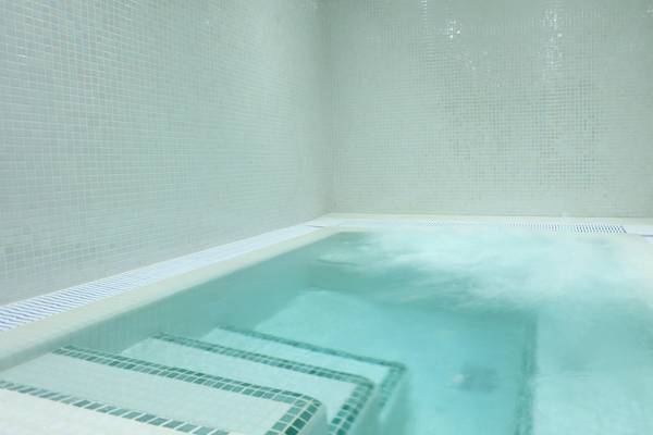 Innenansicht des Poolbereichs im Iberostar Selection Playa de Palma Hotel mit weißen Kacheln und Wasser