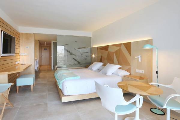 Innenansicht eines Hotelzimmers im Iberostar Selection Playa de Palma mit Bett, Tisch, Stühlen und Fernseher.