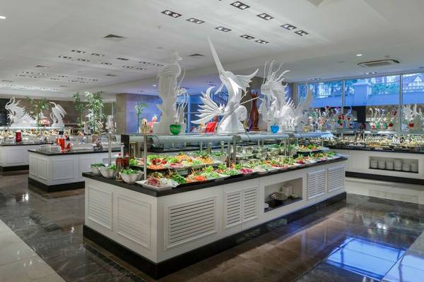 Buffetbereich im Well Palace Side Hotel mit verschiedenen Speisen und Dekoration.