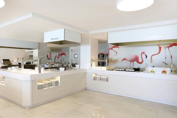 Speisebereich im Iberostar Selection Playa de Palma Hotel mit Flamingo-Wandgemälde und weißen Möbeln.