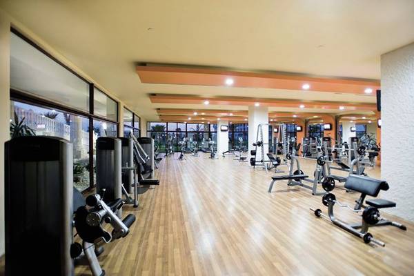 Fitnessstudio im Defne Defnem Hotel mit vielen Geräten und großen Fenstern.