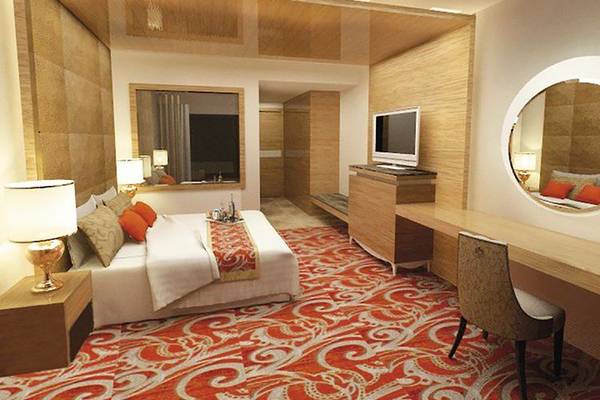 Hotelzimmer von Defne Defnem mit großem Bett, zwei Nachttischen, Schreibtisch, Stuhl, Spiegel und Fernseher.