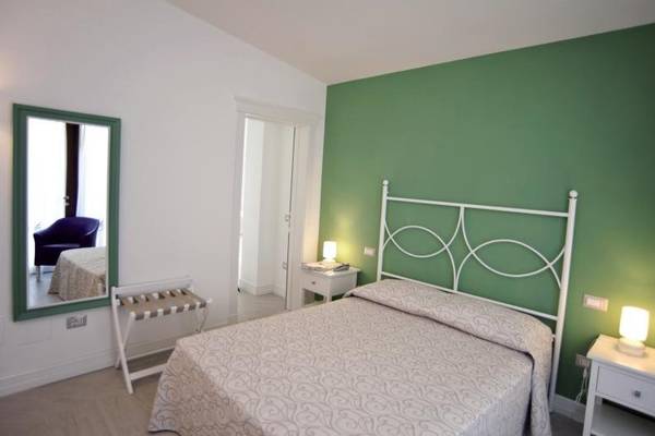 Hotelzimmer mit Bett, Spiegel und Nachttisch im Hotel Residence il Porto