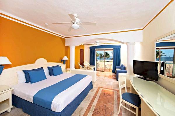 Hotelzimmer mit Bett, Schreibtisch und Meerblick im Bahia Principe Grand Tulum.