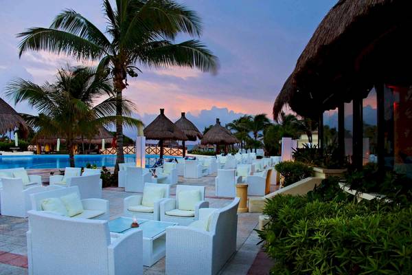Loungebereich des Bahia Principe Grand Tulum mit weißen Möbeln und Palmen