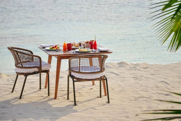 Tisch am Strand des Dhigali Maldives mit Essen und Getränken