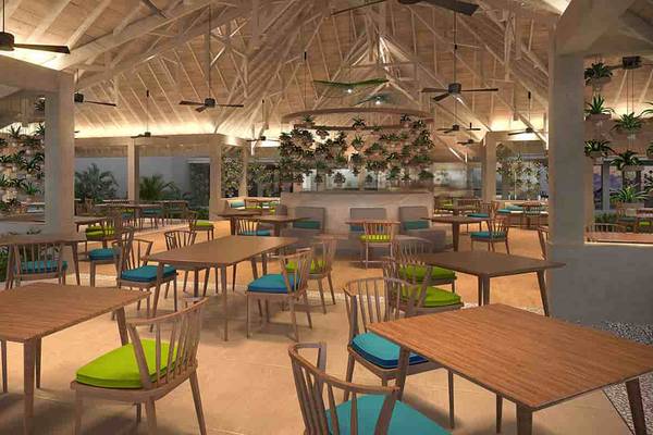 Innenansicht des Restaurants des Dhigali Maldives mit runden Tischen, Stühlen und Hängepflanzen.