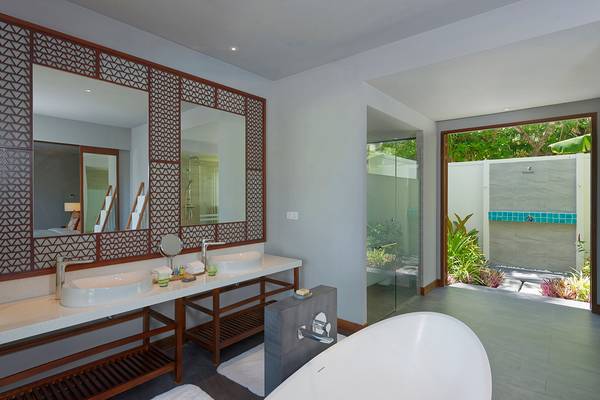 Badezimmer im Dhigali Maldives Hotel mit zwei Waschbecken, Badewanne und offenem Badezimmer.