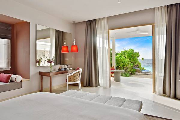 Hotelzimmer im Dhigali Maldives mit Meerblick, Bett, Schreibtisch und Fernseher.
