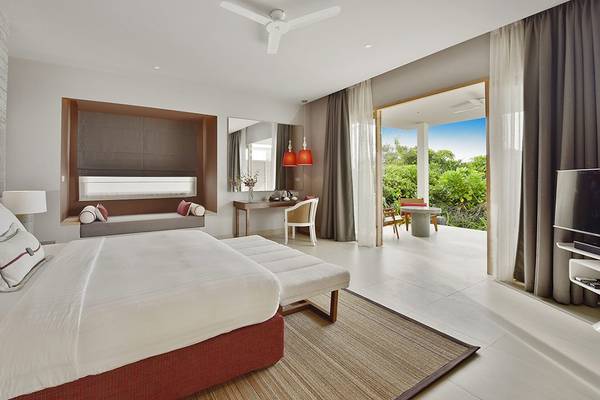Schlafzimmer im Dhigali Maldives Hotel mit offenem Balkon und Meerblick.