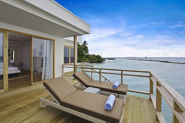 Balkon des Dhigali Maldives mit Blick auf das Meer und zwei Liegen mit Handtüchern.