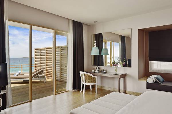 Suite Zimmer im Dhigali Maldives mit Meerblick, Schreibtisch, Spiegel und Fernseher.