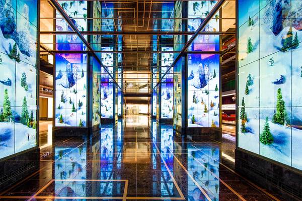 Eingangsbereich des Cosmopolitan of Las Vegas mit blau beleuchteten Wänden und Schneelandschaftsbildern.