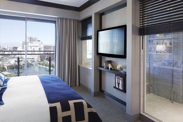 Suite mit Bett und Fernseher im Cosmopolitan von Las Vegas mit Blick auf die Stadt.