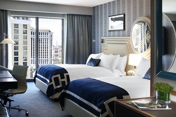 Suite-Zimmer im Cosmopolitan Hotel in Las Vegas mit zwei Betten, Ausblick auf die Stadt, blauer und weißer Bettwäsche.